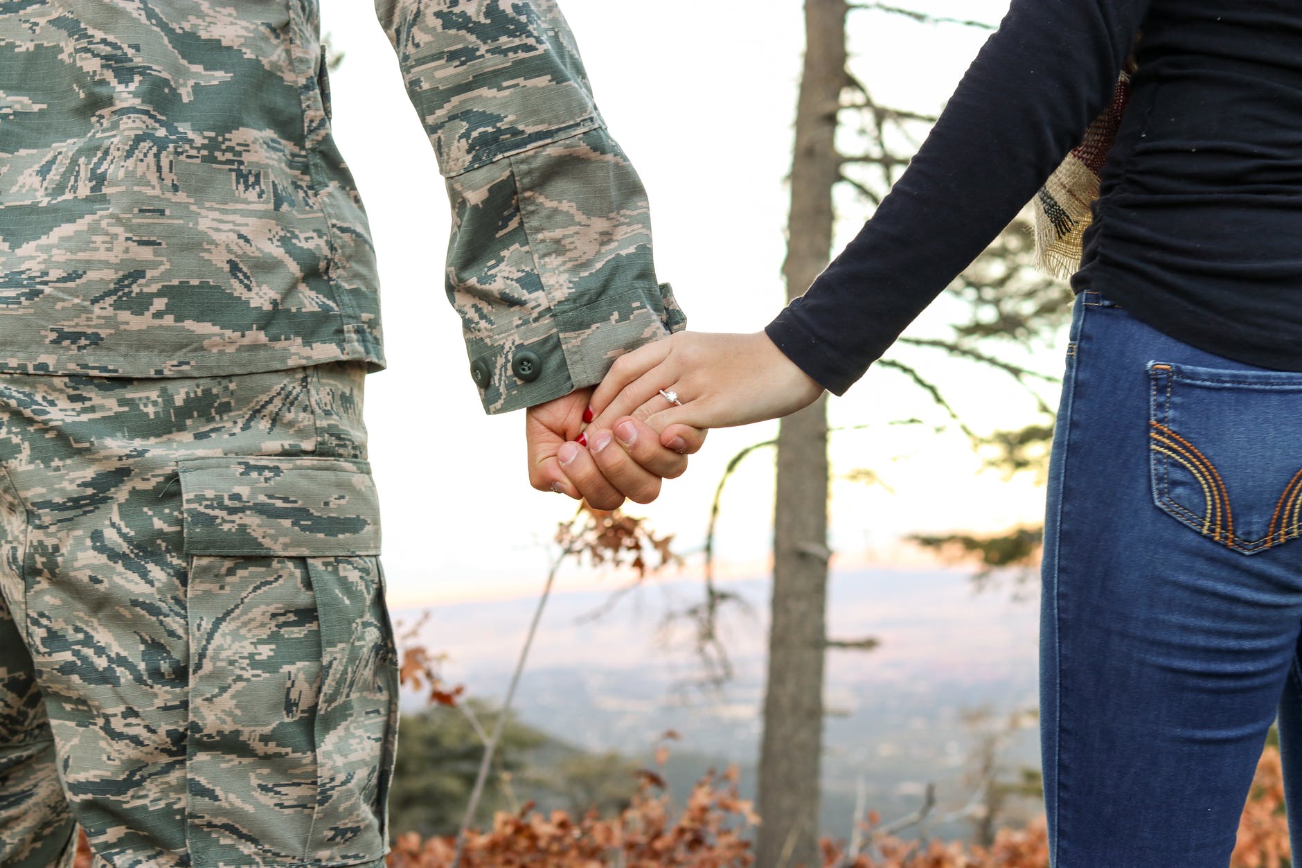 An Army member and his wife holding hands.